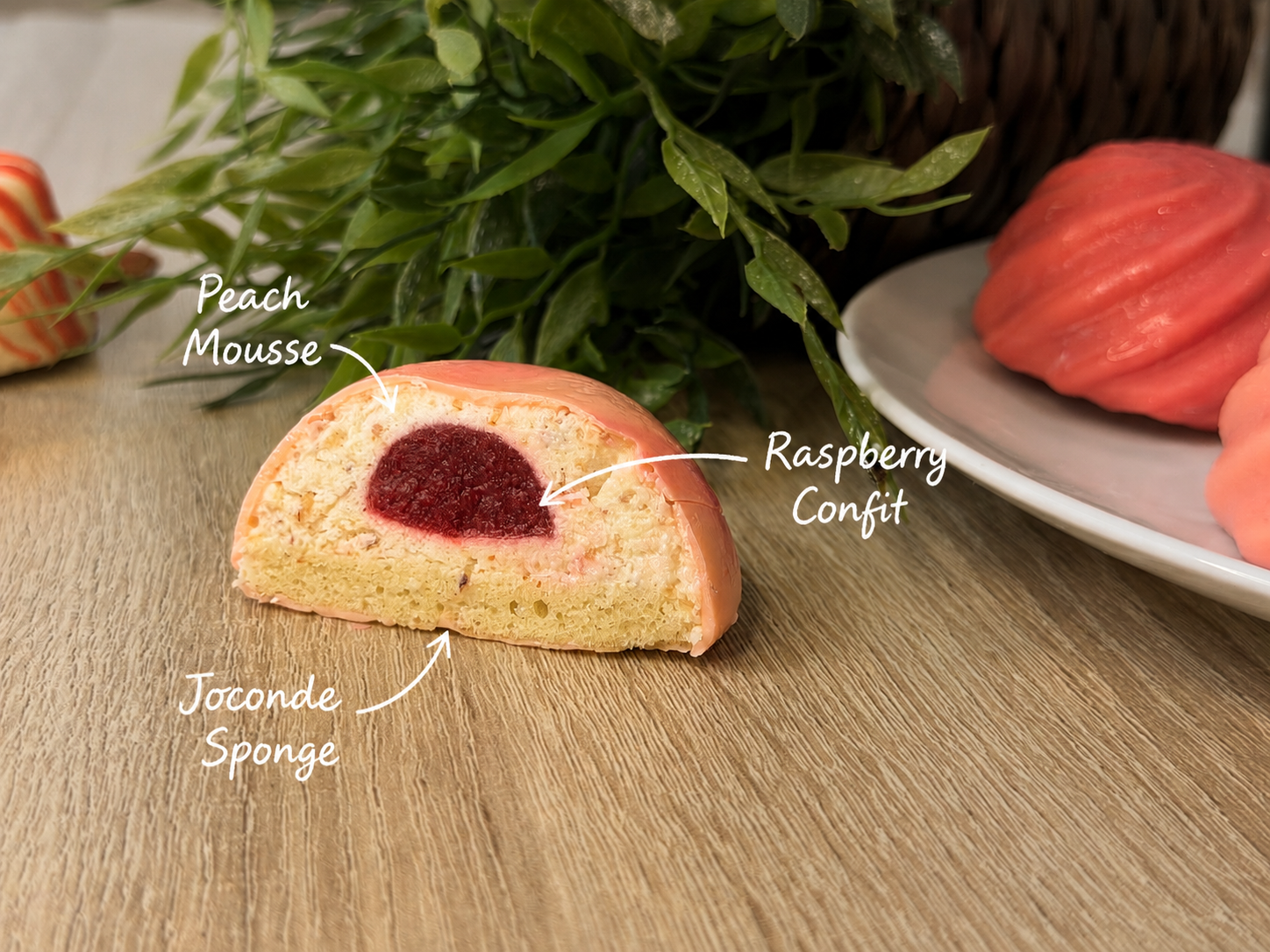 The layers inside: peach mousse, a raspberry confit heart, and an almond joconde base